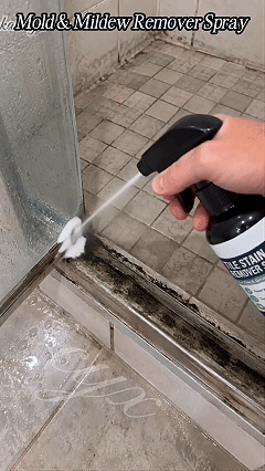 Original Cuoeo animated demonstration of cleaner sprayed at dark tile joints near shower threshold